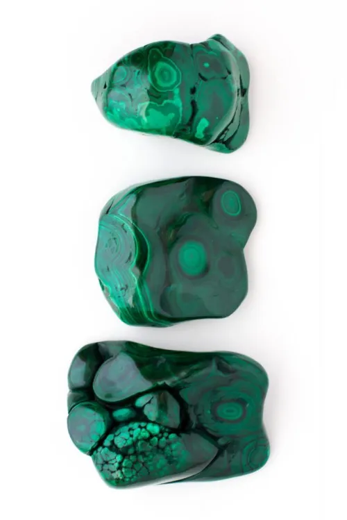 Diagram contrasting Malachite's green crystalline structure (Cu2CO3(OH)2) with Azurite's blue structure (Cu3(CO3)2(OH)2), highlighting the critical Cu ions responsible for color