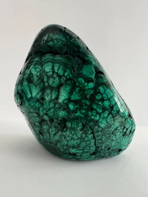 Microscopic view of malachite crystal structure dissolving in water showing copper ions