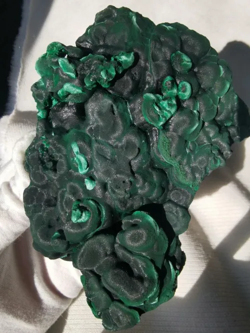 pH test strip beside malachite underwater in glass container