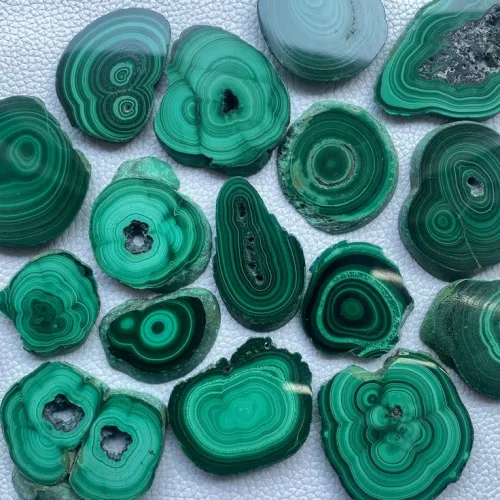 Polished malachite jewelry showing protective bezel settings