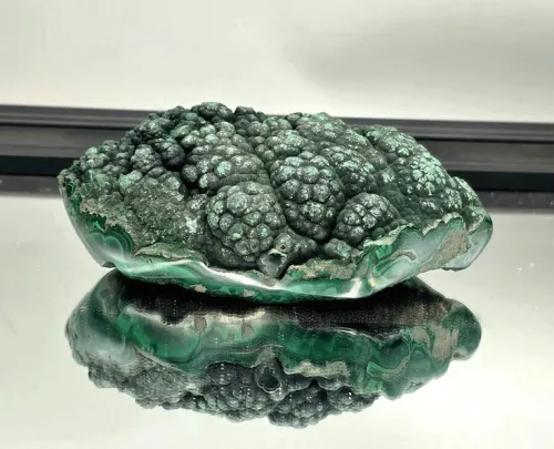 Polished malachite showing concentric rings versus raw sample