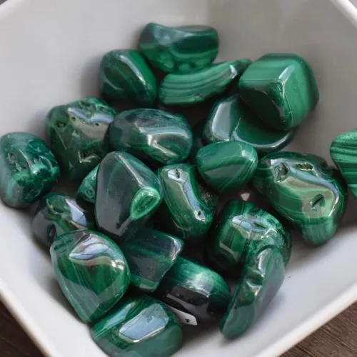 Wet-cutting malachite on diamond lapidary wheel showing watery slurry containment
